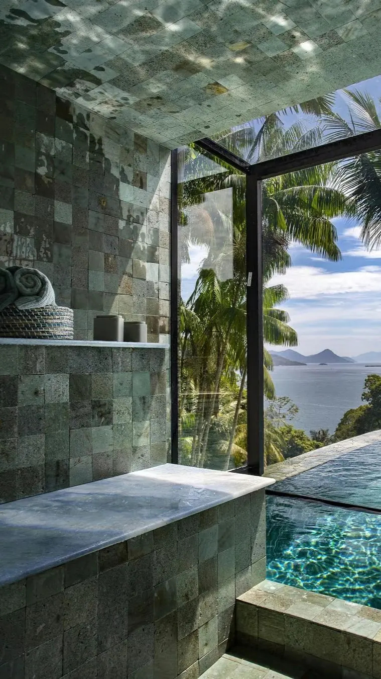 Bathroom with green stone wall tiles and a stone ledge