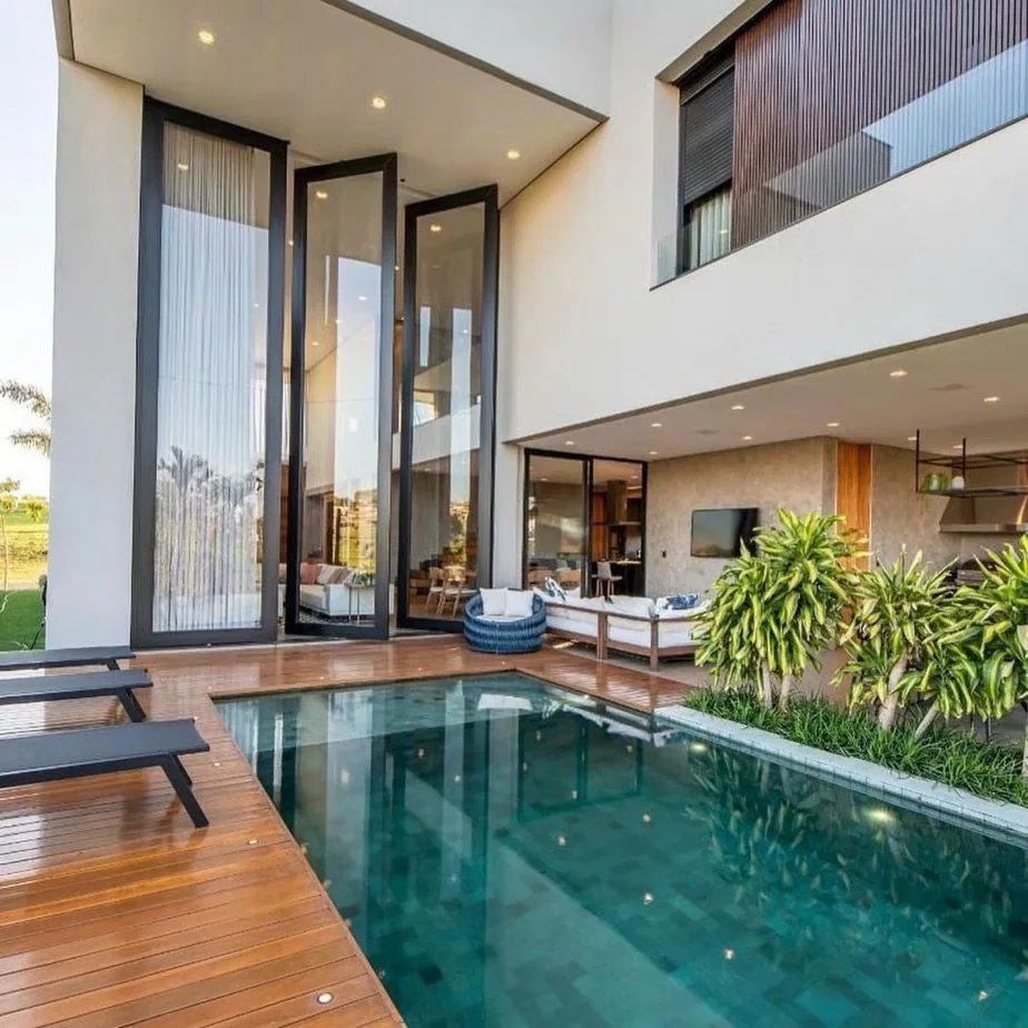 House exterior with a wooden deck and a green tiled pool